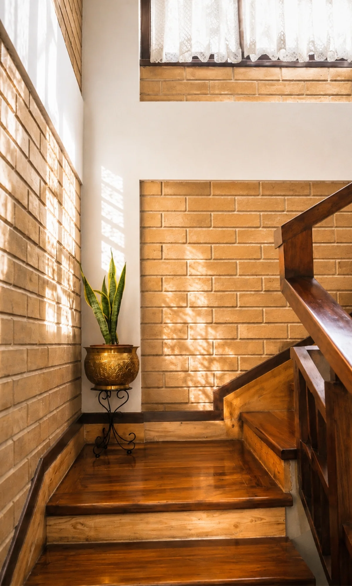 A stairwell walled in exposed earth block, dappled sunlight falling along the courses